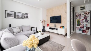 Ein modernes Wohnzimmer mit Sofa, Couchtisch und Fernseher.
