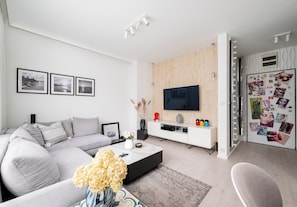 Een moderne woonkamer met een bank, salontafel en televisie.