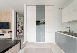 Een moderne keuken met een inbouwoven, een spoelbak en een aanrecht.