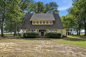 A two-story house with a gabled roof, a front porch, and a small front yard.