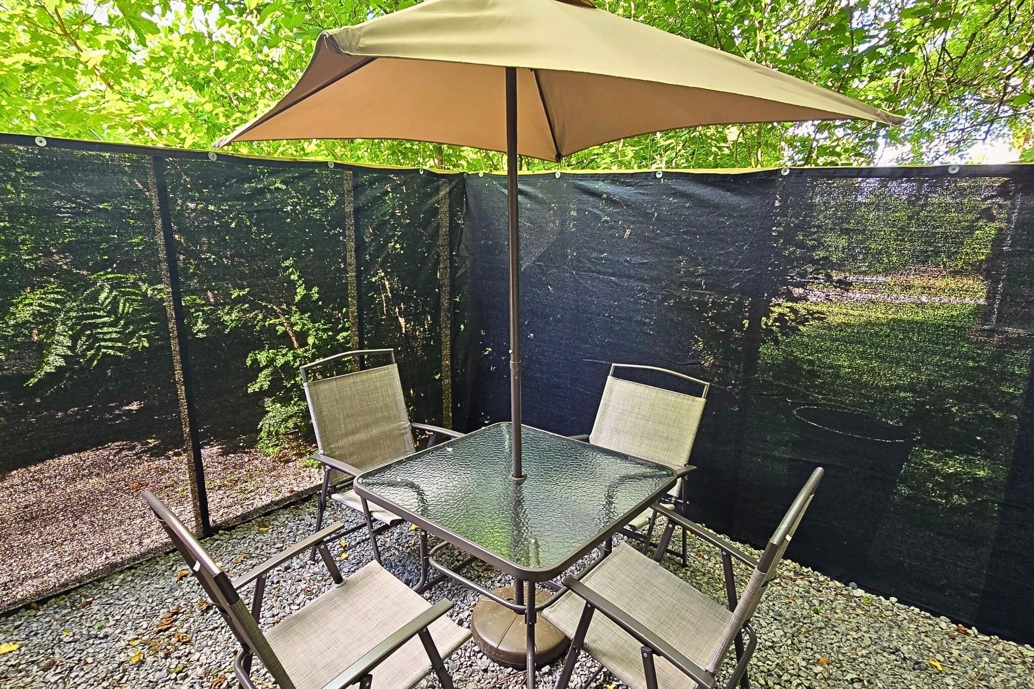 Private shaded patio with umbrella dining in a peaceful wooded setting