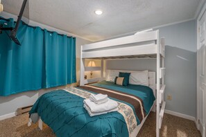 A bunk bed room with a teal bedspread, a folded white towel on the lower bunk, and a window with teal curtains. - ML 219 bike in/bike out Cozy 1-bedroom condo in Mountain Lodge Snowshoe (Snowshoe)