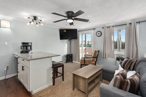 A compact living space with a kitchenette, a ceiling fan, a flat-screen TV, a sofa, and a dining area. - ML 219 bike in/bike out Cozy 1-bedroom condo in Mountain Lodge Snowshoe (Snowshoe)