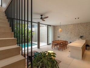 A modern interior with a staircase, a dining area, and a pool. - Villa Marma (Bali)