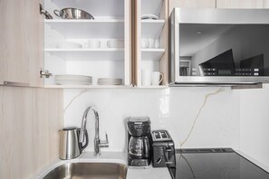 A modern kitchen with a built-in microwave, a coffee maker, and a toaster. - Blueground | SoHo, view, nr Washington Square Park (New York)
