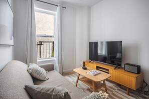Ein modernes Wohnzimmer mit einer Couch, einem Couchtisch, einem Fernseher und einer Stereoanlage.