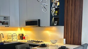 Une cuisine moderne avec un îlot central, des tabourets de bar et une table à manger.