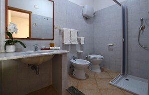 Ein Badezimmer mit Waschbecken, Toilette, Bidet und Dusche.