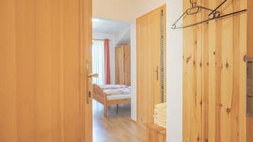 Una stanza in legno con un letto, un armadio e un attaccapanni.