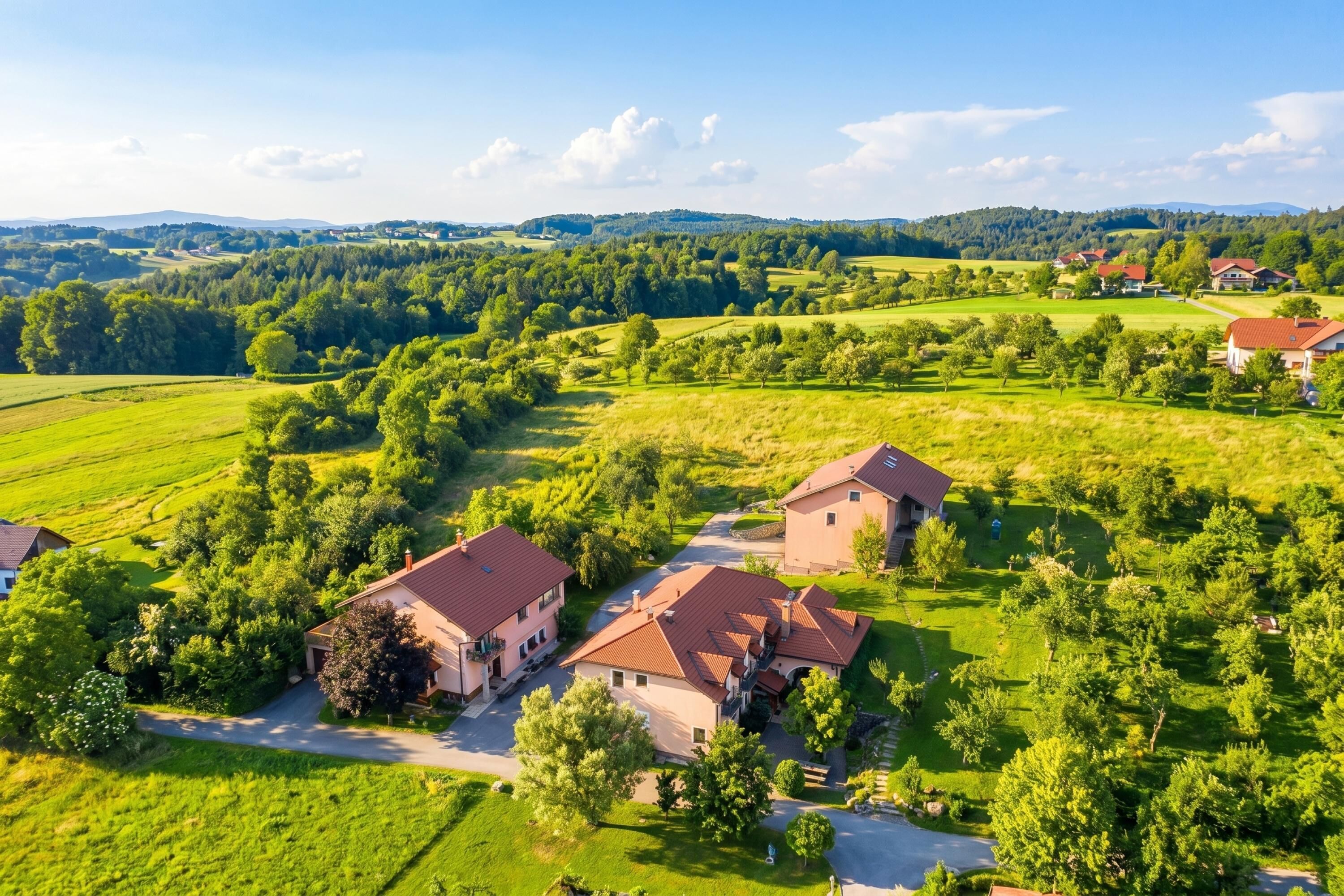 A residential area with houses, green fields, and a clear sky.