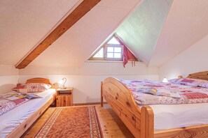 A bedroom with two wooden beds, a small window, and a sloped ceiling. - Pivka Apartment With Terrace, Pivka, Slovenia (Pivka)