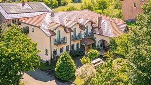 A large, multi-story house with a red-tiled roof, multiple balconies, and a well-maintained garden. - Pivka Apartment With Terrace, Pivka, Slovenia (Pivka)