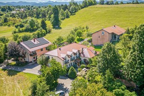 A large house with a red roof, surrounded by lush greenery and a clear sky. - Pivka Apartment With Terrace, Pivka, Slovenia (Pivka)