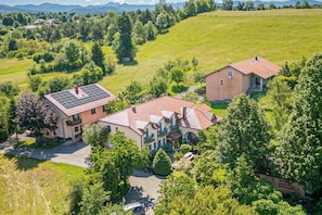 A large house with a red roof, surrounded by lush greenery and a clear sky. - Pivka Apartment With 2 Balconies, Pivka, Slovenia (Pivka)