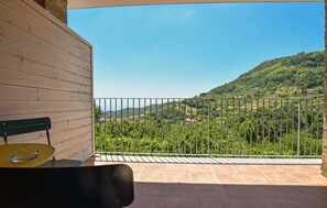 Ein Balkon mit Blick auf eine hügelige Landschaft.