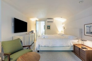 Een hotelkamer met een bed, een televisie, een bureau en een stoel.