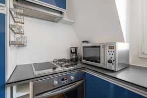 A kitchenette with a gas stove, a microwave, and a coffee maker. - Bright 1BDR Retreat in Paris 15th (Paris)