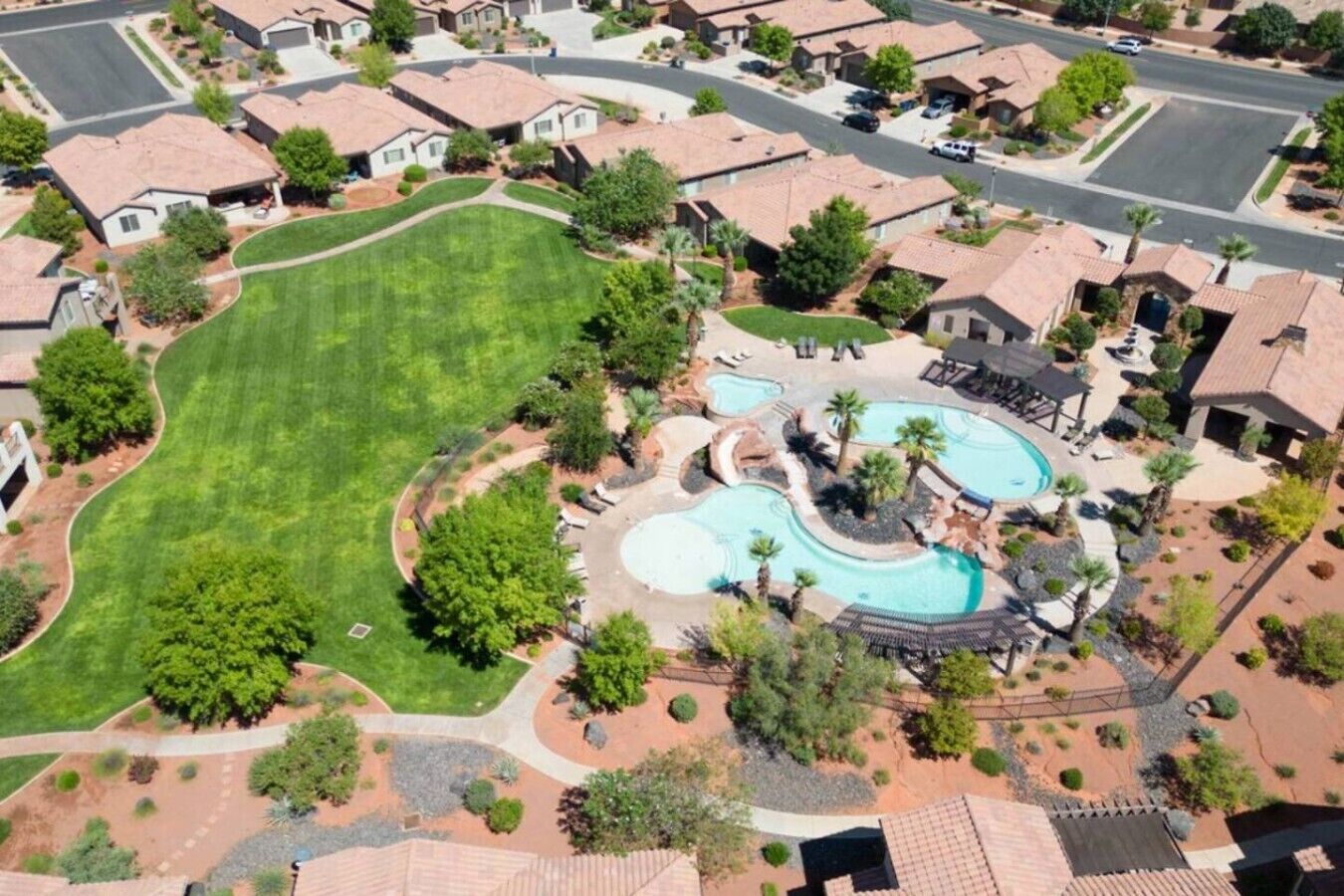 A residential area with houses, a large lawn, and a swimming pool complex.