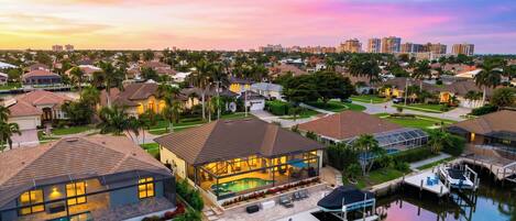 A residential area with houses, a swimming pool, and a dock by the water.