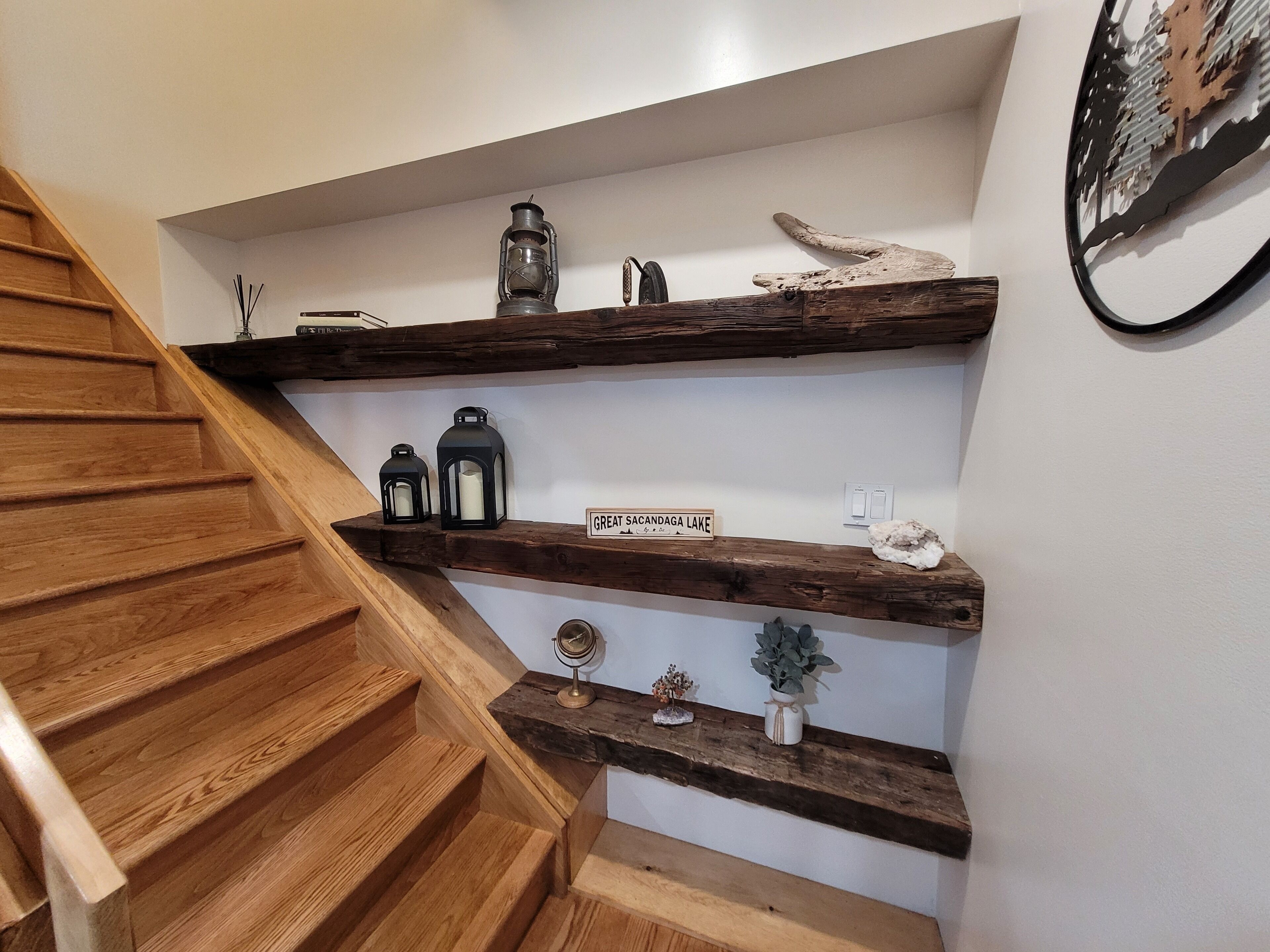 Un escalier en bois, avec une pancarte indiquant «Grand lac Sacandaga» sur le palier.