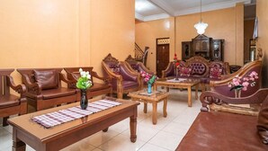 A living room with wooden furniture, a chandelier, and a staircase. - Koolkost Syariah Jalan Cangkringan Kaliurang (Ngemplak)