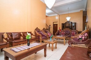 Una sala de estar con muebles de madera, una araña y una escalera.