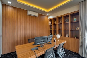 A modern office space with a wooden desk, two monitors, a globe, and a shelf with decorative items. - The Queeno Hill Villa - Nusa Dua (Nusa Dua)