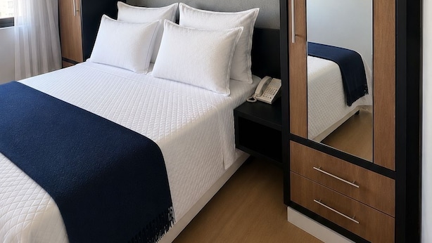 A hotel room with a bed, a wardrobe, and a bedside table. - Premium apartment in Tatuapé with pool, gym and garage included. (São paulo)