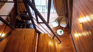 A wooden staircase leading to a balcony with two white chairs and a small table. - EL Cabana (Kuta Selatan)