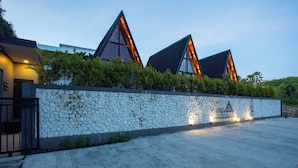 Un edificio moderno con pared de piedra y techos triangulares.