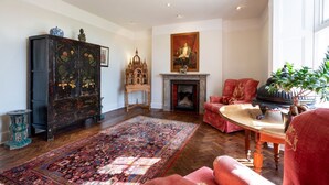 A traditional room with a fireplace, a large rug, and classic furniture.
