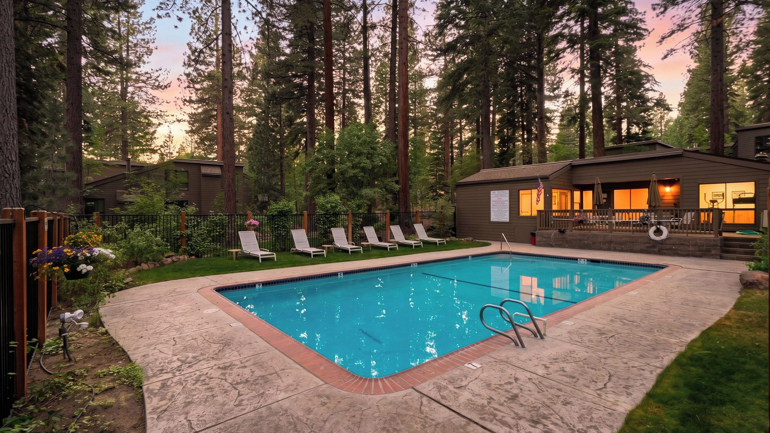 Une piscine rectangulaire bordée de briques, entourée d’une terrasse en bois.