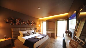 Una camera d'albergo con un letto grande, un comodino, una lampada a parete, un armadio e uno specchio.
