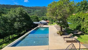 Una piscina rettangolare con superficie d'acqua cristallina e azzurra, circondata da un solarium in cemento.
