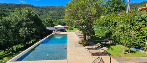 A rectangular swimming pool with a clear blue water surface, surrounded by a concrete deck.