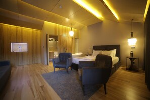 A modern hotel room with a bed, two armchairs, a TV, and a bedside table. - Rio Moment S (Castelo de Paiva)