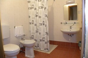 Un baño con inodoro, bidé y lavabo.