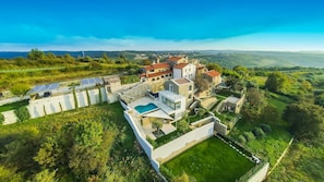 A modern villa with a swimming pool, solar panels, and a view of the surrounding countryside. - Villa Zimzelen - Four Bedroom Villa, Sleeps 10 (Merišće)