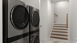 A modern laundry room with two front-loading washing machines. - Emerald Retreat by Avantstay Sleeps 44 + Pool + Spa Theater + Game Room Walk to Beach (Miramar Beach)