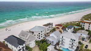 Um hotel à beira-mar com vários edifícios, uma praia e uma piscina.