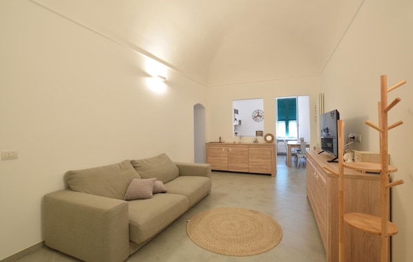A living room with a sofa, a wooden cabinet, a television, and a coat rack. - 2 bedroom beautiful apartment in Loano (Loano)