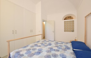 A bedroom with a bed, wardrobe, arched window, and a door leading to another room. - 2 bedroom beautiful apartment in Loano (Loano)