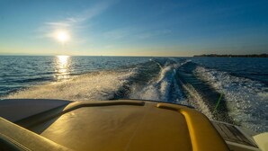 A boat's interior with a view of the water and a distant shoreline. - Bodenseezeit Apartmenthotel Garni (Wangen im Allgäu)
