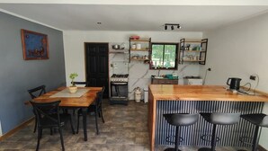 Una cocina compacta con comedor, una barra y una pequeña isla con taburetes.