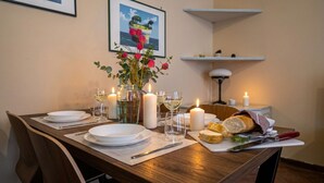 A dining table set with plates, glasses, candles, and a loaf of bread. - Italianway Easy - Corso San Gottardo 5 (Milano)