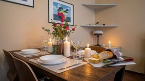 A dining table set with plates, glasses, candles, and a loaf of bread. - Italianway Easy - Corso San Gottardo 5 (Milano)