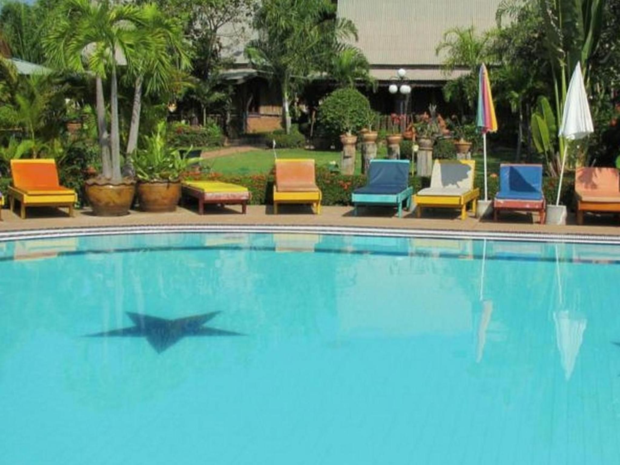 Ein Schwimmbecken mit Liegestühlen und Topfpflanzen.
