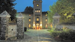 Un hotel con una torre dell'orologio ben visibile, un portale in pietra e un ingresso ben illuminato.