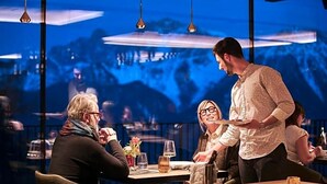 A restaurant with tables, chairs, and hanging lights. - Olangerhof Hotel Spa (Valdaora)
