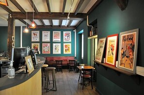 En restaurantindretning med disk, siddepladser og plakater på væggen.